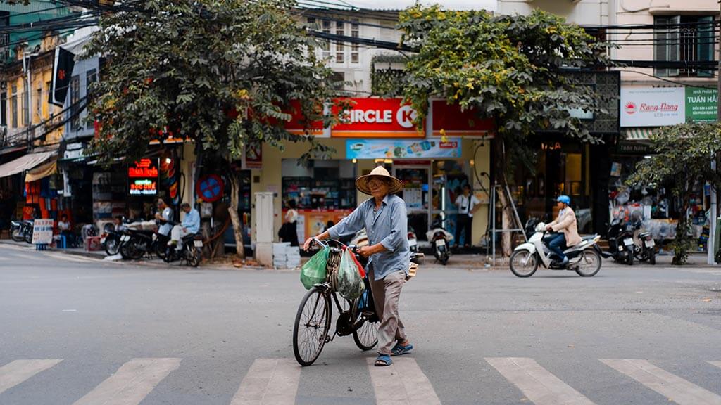 Man pushing bike in Hanoi Vietnam